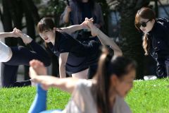 インストラクターの動きを見ながらヨガのポーズをとる堀川桃香（中央奥）＝金野和彦撮影