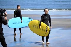 サーフボードを抱え海へ向かう高木美帆（金野和彦撮影）