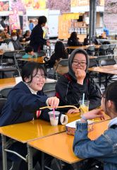 帯広競馬場で開幕した「うまちか」で、談笑しながら食事を楽しむ来場客（３日正午ごろ、塩原真撮影）