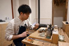 工房で作業に取り組む辻さん。ガスバーナーの炎で金属を熱し、柔らかくすることで好みの形に変形させることができる