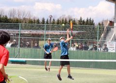 【男子１８歳以下複・決勝】バックのハイボレーを決める帯緑陽高の河村優亮（手前）。単複２冠を果たした中川旺亮の強力なサーブも光った