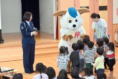 ほくとくんに群がりハイタッチを求める園児ら。左は後藤巡査長