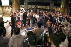 拳を突き上げて盛り上がる会場。中央が牛山選手(黒Tシャツ、提供)