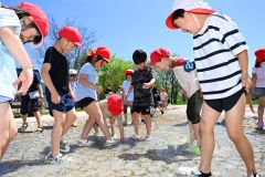 夏のような日差しの下、水遊びを楽しむ柏小の１年生（１６日午前１１時ごろ、帯広市の光南緑地公園で。須貝拓也撮影）