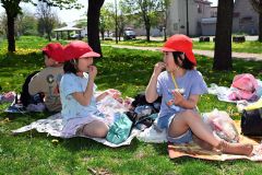 目的地の光南緑地公園に到着し、おやつをほおばる柏小の１年生（１６日午前９時５０分ごろ、須貝拓也撮影）