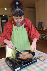 フライパンでつくねを炒める齊藤代表