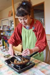 フライパンでつくねを炒める齊藤さん