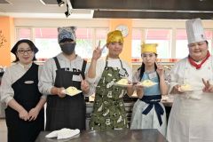 出来上がったケーキを見せる参加者。左は遠藤校長。