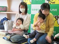 受け取った森の輪に興味を示す乳児