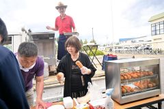 子供たちにあげいもを提供する佐藤さん（手前右）と唯野さん（後方）。左は山本施設長