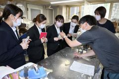歯科技工士から歯科技工物の説明を受ける学生