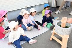 職員のお手本を興味津々で見つめる２歳児たち