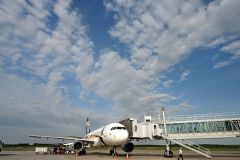 着陸した機体にかけられたブリッジで空港内へと進む乗客（須貝拓也撮影）