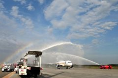 とかち帯広空港に着陸し歓迎の放水を受け、虹の輪の中を進むエアロＫの旅客機（須貝拓也撮影）