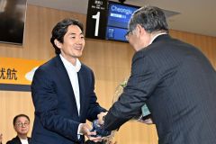 十勝町村会の竹中会長（右）から花束を受け取るカン社長（須貝拓也）
