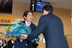北海道道十勝総合振興局の野口局長（右）から花束を受け取るカン社長（須貝拓也撮影）