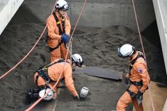 砂に埋まったダミー人形の救出訓練をする署員