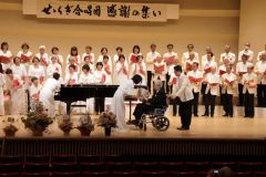 せせらぎ合唱団の65周年記念公演で団員から感謝の花束を受け取る高橋さん