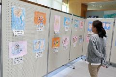 お父さんやお母さんの特長を捉えた似顔絵が並ぶ作品展