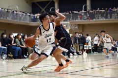【男子決勝リーグ・白樺学園―帯大谷】第２クオーター、相手のディフェンスをかわす白樺学園の佐々木晃太（白色ユニホーム、左）＝金野和彦撮影