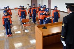 遠藤幹事長（手前）から手帳とバッジを受け取った野村さん