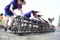 格子状の枠を回し、田植えの目印をつける児童ら