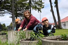 地域の大人や保護者と協力して花苗を植える児童たち
