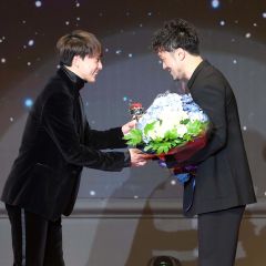 盟友の五十嵐圭（左）からトロフィーを受け取る柏木真介（佐伯航平撮影）
