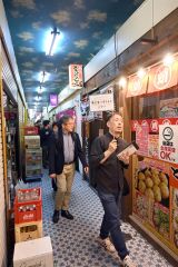 参考になる情報を交え、参加者にまちなかの店を紹介する田中氏（手前）