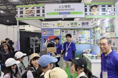 目を輝かせながら上士幌町のブースを訪れた上士幌小児童ら。右は竹中貢町長