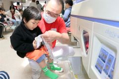 菓子を使った薬の分包機体験に挑戦する子ども