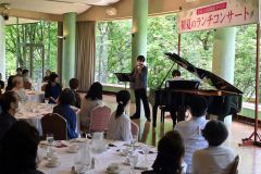 初夏の柔らかな日差しを感じながら、演奏と食事を楽しんだ出席者ら
