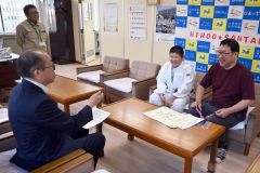 山岸教育長（左）に大会の結果を報告する尾矢さん（中央）