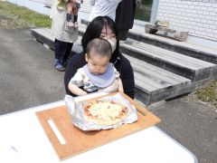 焼く前のピザ生地を見る子ども