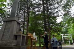 交通安全祈願碑前の祭壇に玉串をささげ、手を合わせる藤川会長