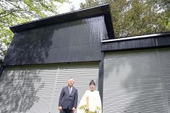外装などが化粧直しされた舞台の前に立つ長屋さん（左）と佐々木宮司（右）