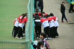 ベンチ外の部員とフェンスを挟んで円陣を組む帯大谷女子。結束力の高さを垣間見せた