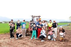 第１回のイベントを終え、トラクターの前で記念撮影する参加者たち