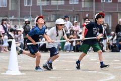 棒引き競技で必死の形相をしながら棒を回すインコースの３年生男児（７日、帯広光南、須貝拓也撮影）