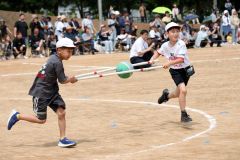 ３、４年生による競技「はさんで　はこんで」。協力しながらボールを運ぶ児童ら（７日、帯広、助川かおる通信員撮影）