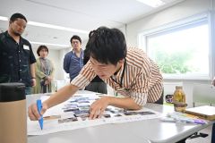 完成したコラージュにタイトルをつけている参加者ら