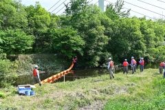 油流出を想定し、迅速にオイルフェンスを設置する参加者
