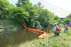 油流出を想定し、迅速にオイルフェンスを設置する参加者