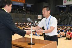 道高体連バレーボール専門部から表彰状を受け取る帯南商の鈴木和彦氏（右手前）＝金野和彦撮影