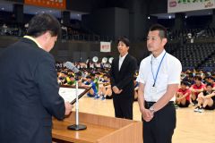道高体連バレーボール専門部から表彰状を受け取る帯広南商業高校の鈴木和彦氏（右手前）と札幌北稜高校の葛西高成氏（左奥）＝金野和彦撮影