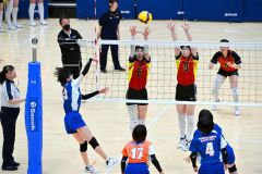 【女子予選グループ・帯南商―東海大札幌】第２セット、ブロックに飛ぶ帯南商の唐﨑愛華（赤色ユニホーム、左手前）と大槻清香（同、右手前）＝金野和彦撮影