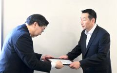蒔田所長から認定書を受け取った田中社長（右）