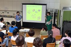 豆と野菜による健康効果を説明する萬谷さん（左）