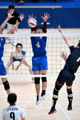 【男子決勝・東海大札幌―札幌大谷】第２セット、ブロックに飛ぶ東海大札幌の松村翔生（青色ユニホーム、中央、緑南中出）＝金野和彦撮影