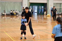 バレーボール少年団の児童を指導する大友さん（右）